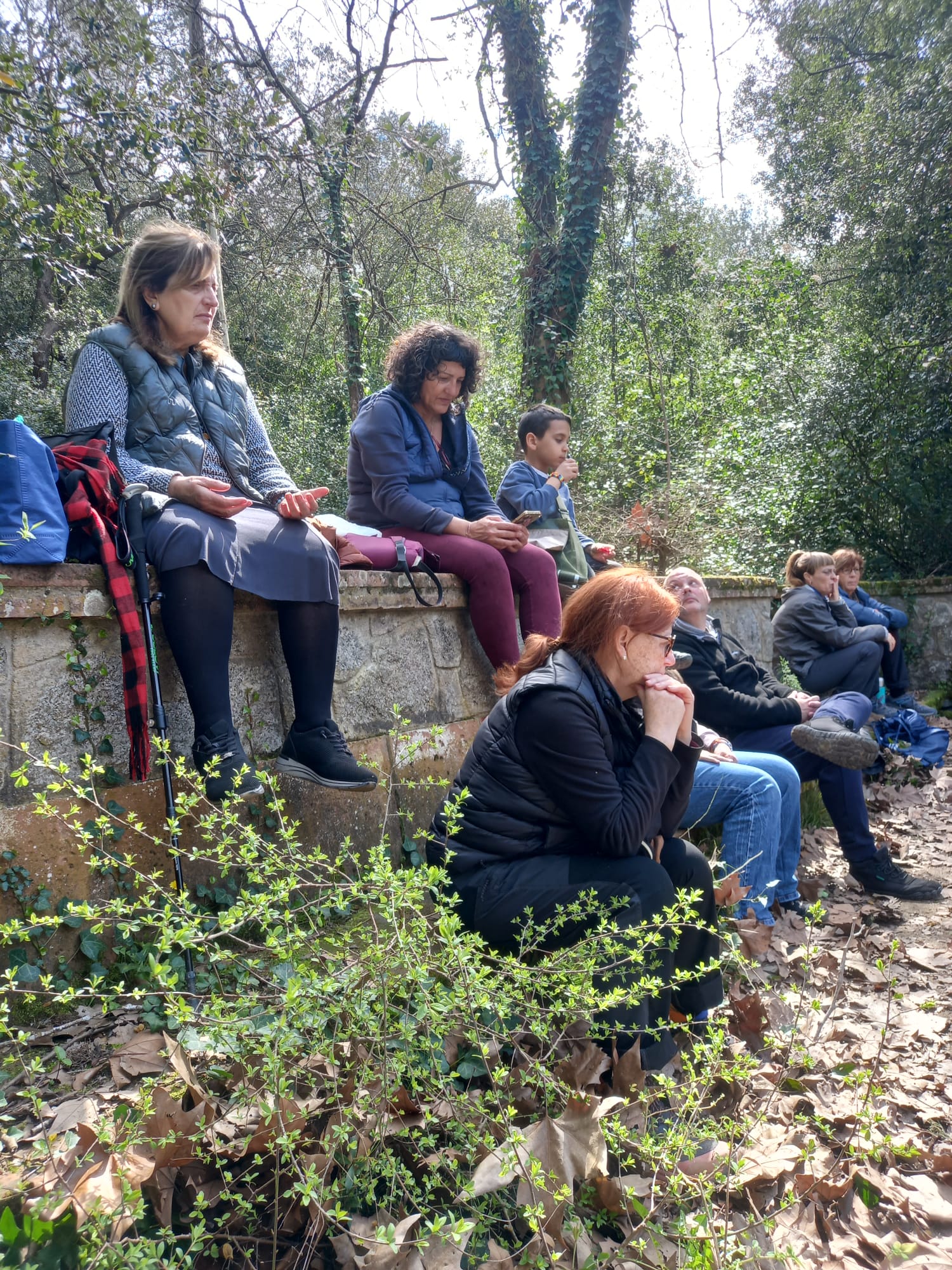 Grupo descansando y escuchando en un entorno natural durante una paseada aromática