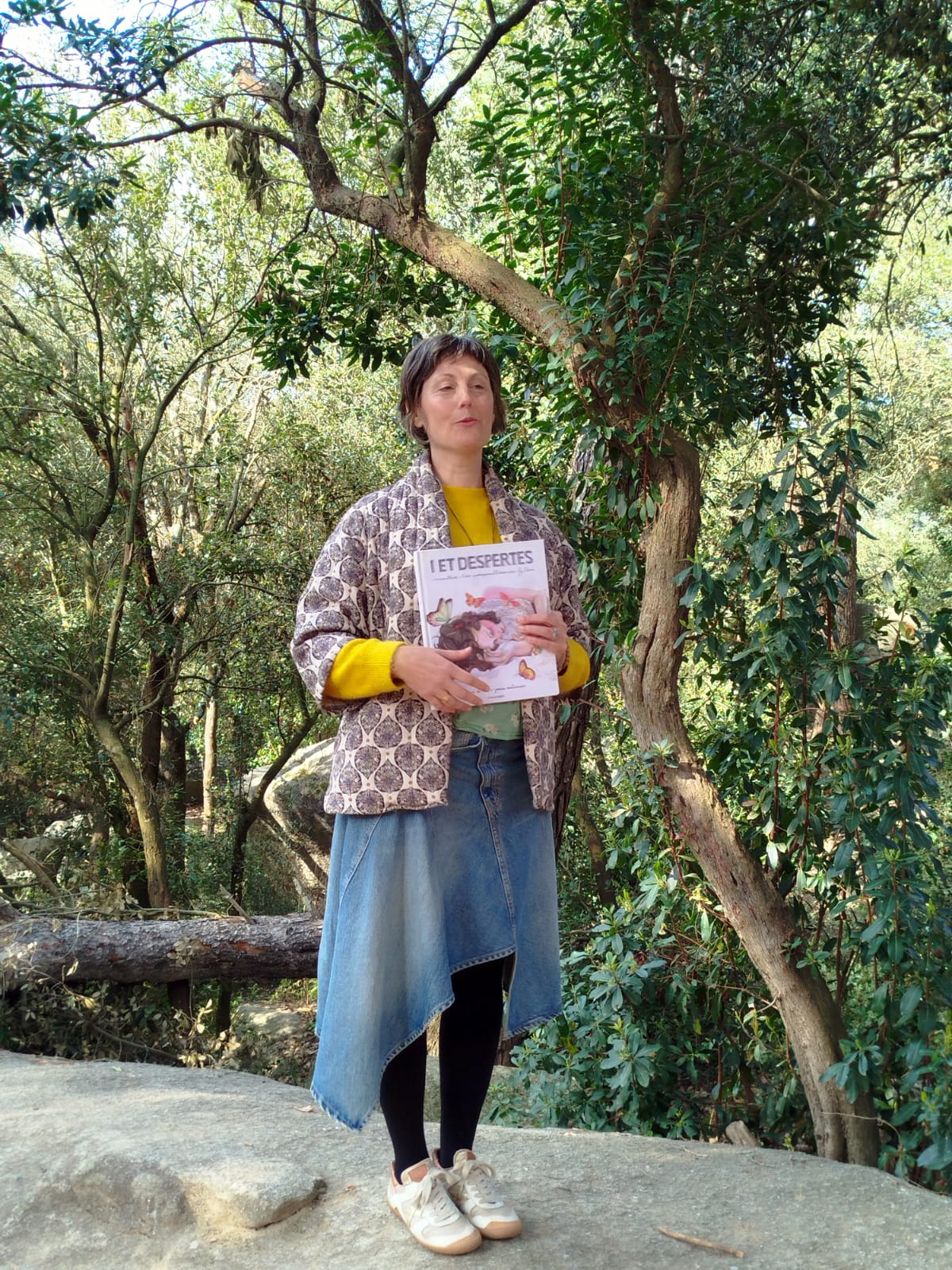 Mujer sosteniendo un libro en medio del bosque durante una paseada aromática